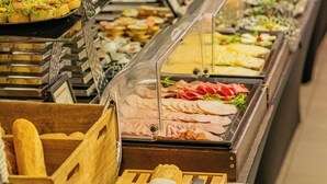 Un buffet proposant une variété de plats, notamment des salades, des viandes et des desserts.