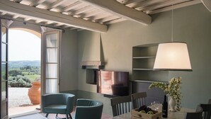 Un comedor con una mesa, sillas, un televisor y vistas al exterior.