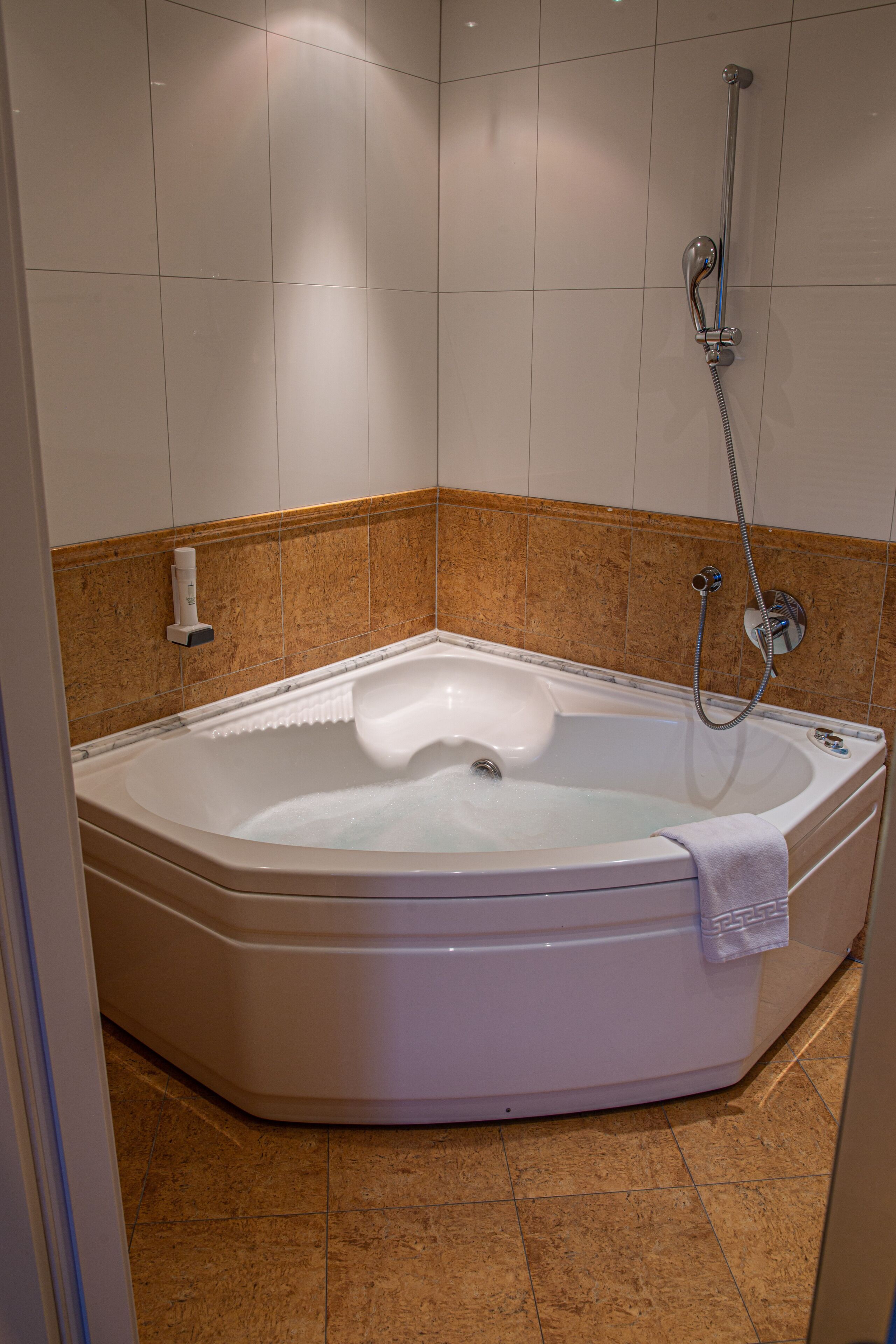 Un baño con bañera, ducha y toallero.