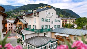 A hotel with multiple floors, balconies, and a view of the surrounding town and mountains. - HEITZMANN - Hotel & Rooftop (Zell am See)