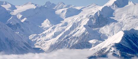 Eine Berglandschaft mit schneebedeckten Gipfeln und einem Tal darunter.