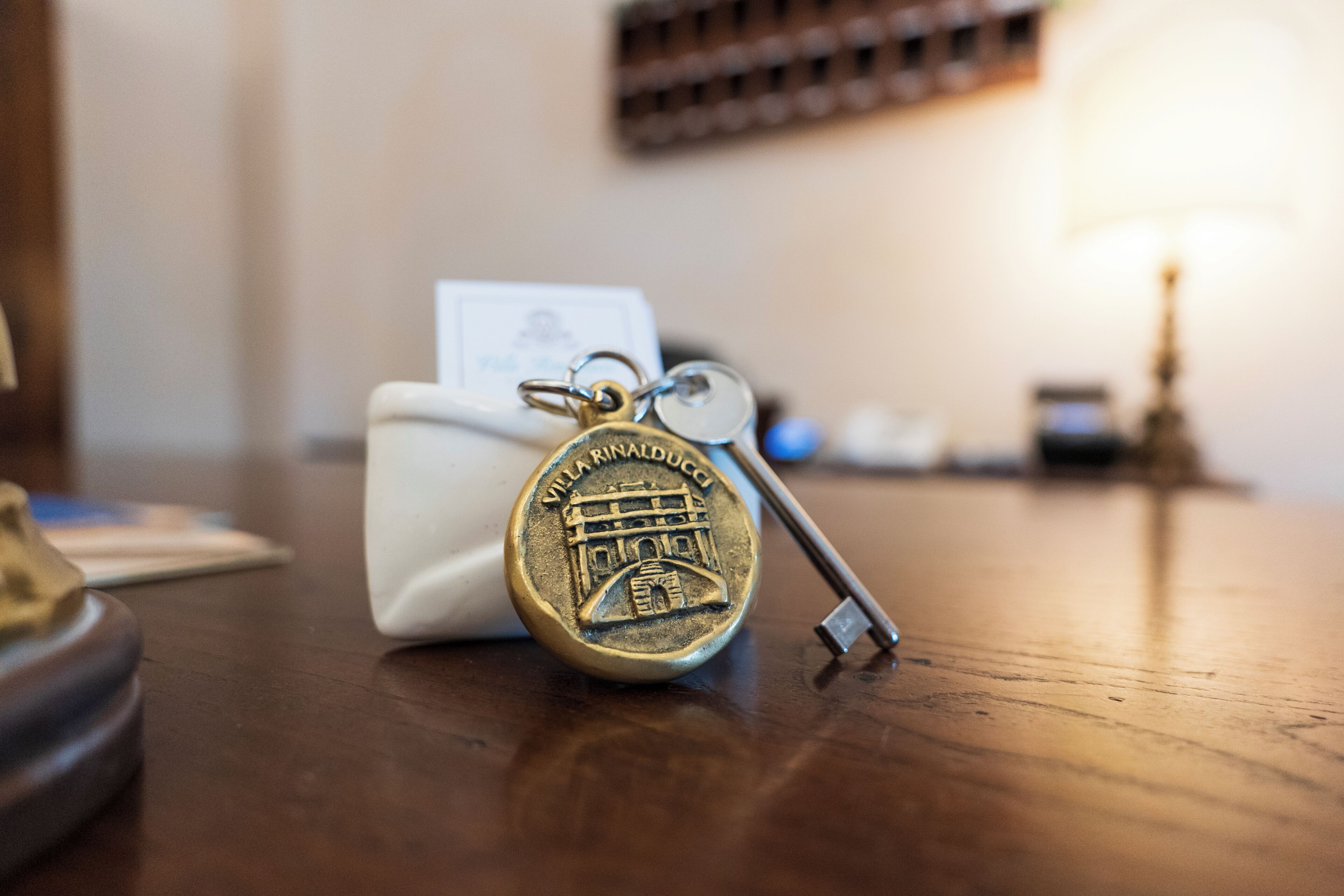 A key with a keychain and a card on a wooden surface.