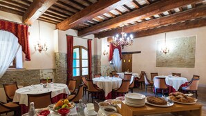 A dining area with multiple round tables, chairs, and a buffet table with various food items. - Villa Rinalducci (Fano)