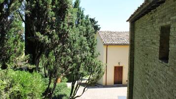 Un patio con un sendero de piedra, una puerta de madera y un edificio de ladrillo.