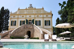 A large building with a pool and outdoor seating.