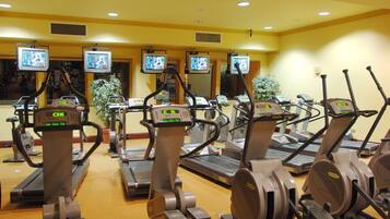 A gym with multiple treadmills and stationary bikes, each with digital displays.
