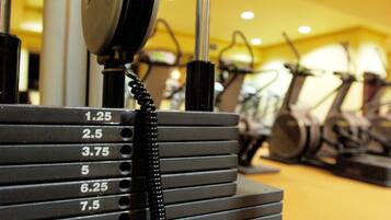 A row of stationary bikes with a coiled cable and a dial marked with numbers from 1.25 to 10.