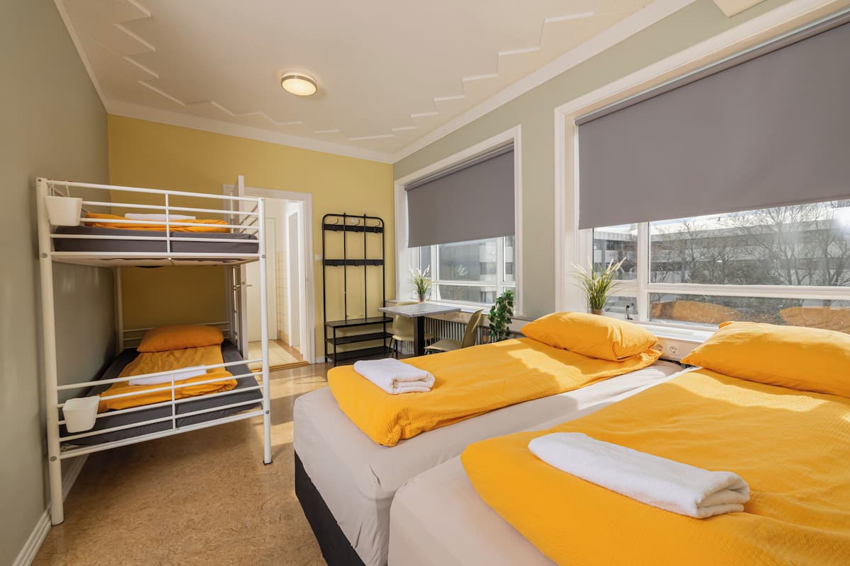 Habitación cuádruple | Cortinas blackout y ropa de cama