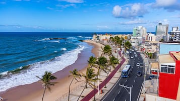 Perto da praia, espreguiçadeiras, guarda-sóis, toalhas de praia