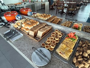 A buffet with various food items and utensils. - Hotel Dan INN Express Salvador By Nacional Inn (Salvador)