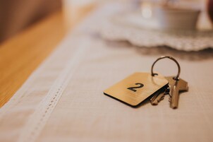 A set of keys with a wooden tag marked "2" on a tablecloth.