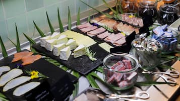 Un buffet proposant une variété de plats, notamment des fromages, des viandes et des condiments.