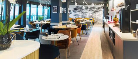 Un restaurante moderno con mesas redondas, sillas e iluminación colgante.