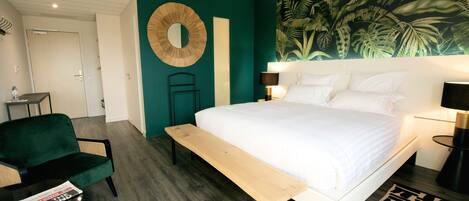 Quarto com cama, mesa de cabeceira, abajur e um banco.