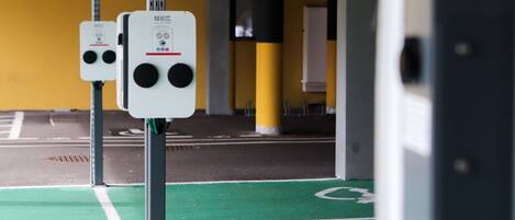 A parking area with green bike lanes and two white parking meters.