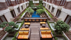 A rooftop pool area with wooden deck seating and planters. - Sense Sunset Hotel Seminyak (Seminyak)