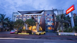 A modern hotel with a unique architectural design, featuring a prominent curved facade and a rooftop terrace. - Sense Sunset Hotel Seminyak (Seminyak)
