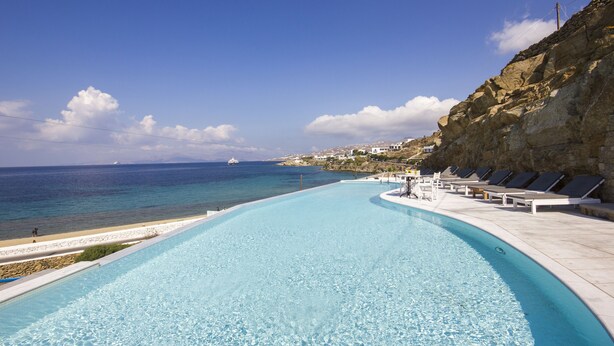 Una piscina con vistas al mar y un acantilado rocoso.