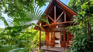 A wooden cabin with a balcony, surrounded by lush greenery. - S Resorts Hidden Valley Bali (Pecatu)