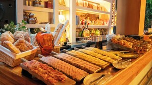A buffet with various food items and a bar area with shelves of bottles.