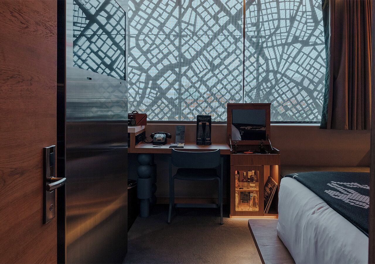 Una habitación de hotel compacta con escritorio, silla y cama.