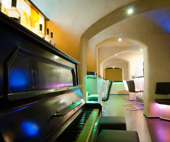 A piano in a well-lit hallway with seating areas and a reception desk. - Hotel Silesia (Görlitz)