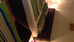 Una habitación con cama, mesita de noche y lámpara.