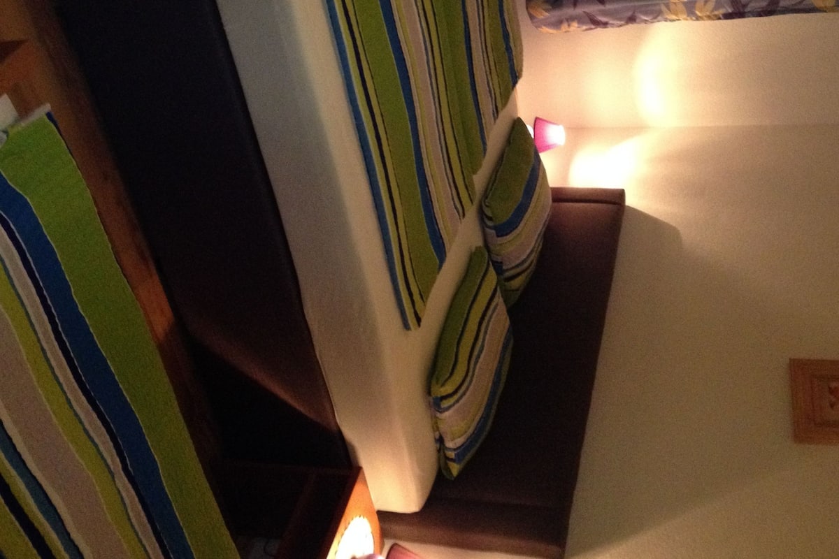 A room with a bed, a nightstand, and a lamp.
