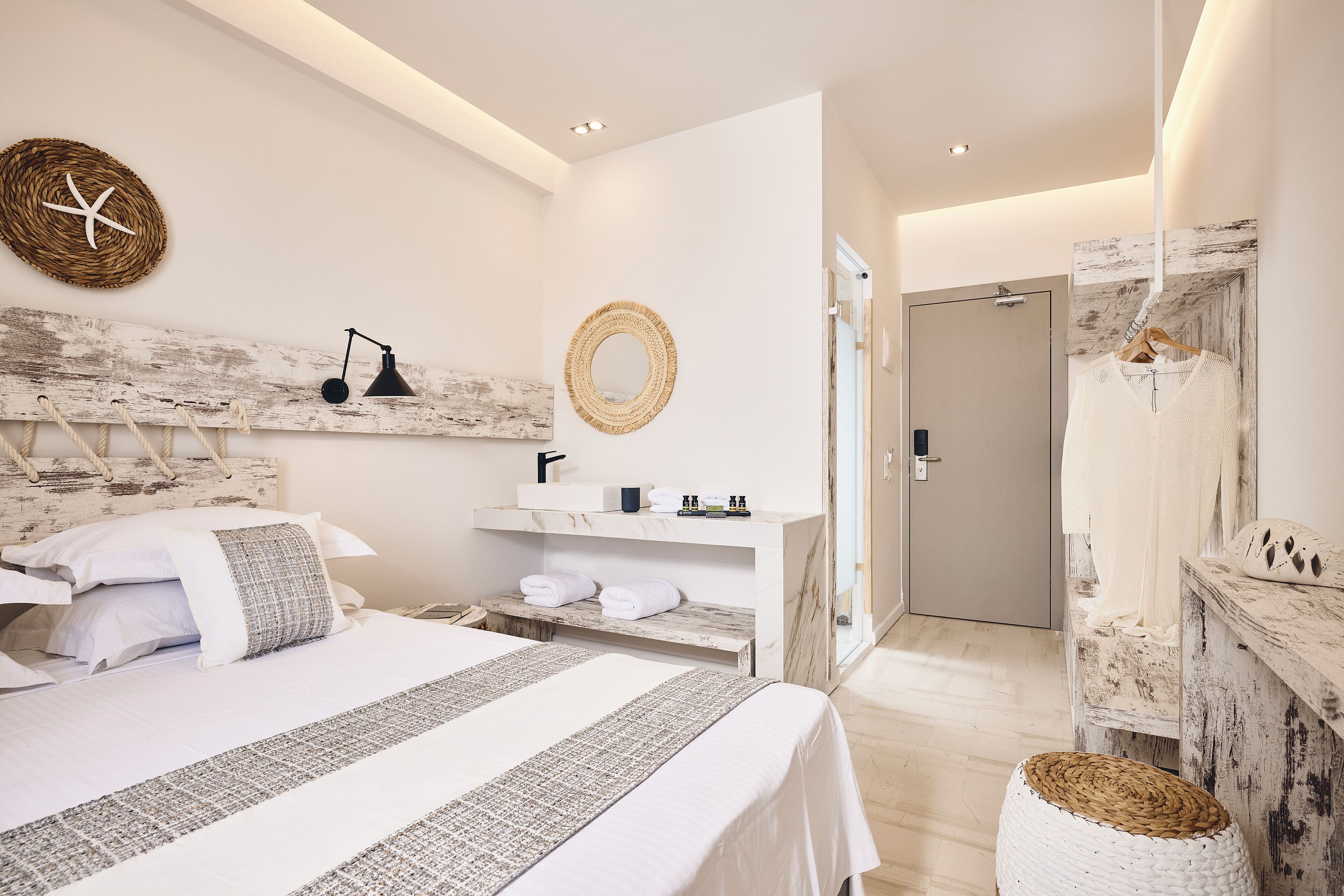 A modern bedroom with a large bed, bedside tables, a hanging light, and a mirror.