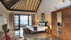A spacious bedroom with a large bed, a sofa, a TV, and a wardrobe. - Destiny Villas and Residence Seminyak (Keroboken Kelod)