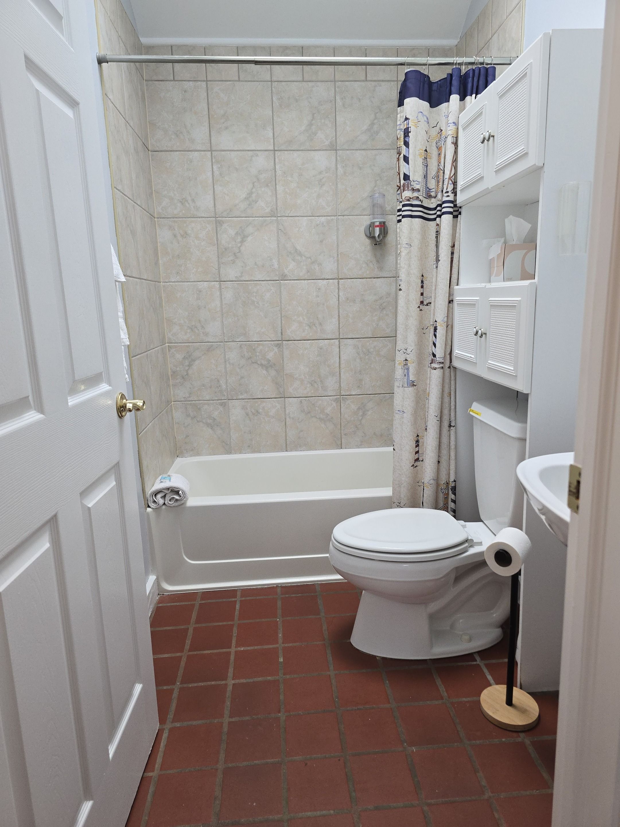 A bathroom with a bathtub, toilet, and a shower curtain.