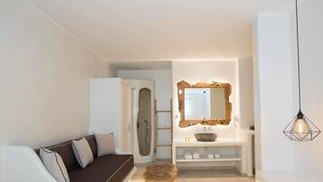 Suite, vista al mar | Área de sala de estar | Televisión de pantalla plana