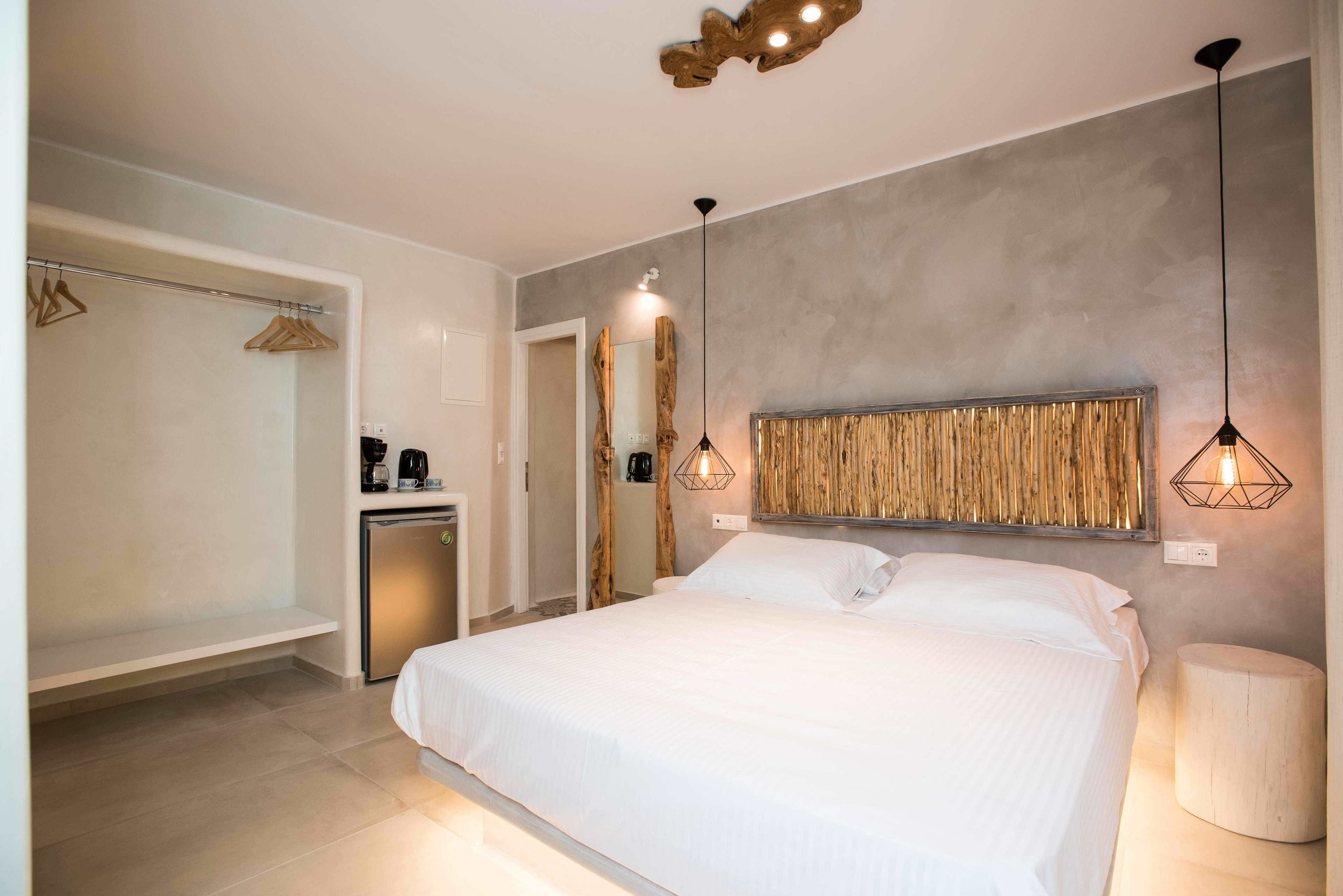 A modern bedroom with a large bed, bedside tables, a wardrobe, and a coffee machine.