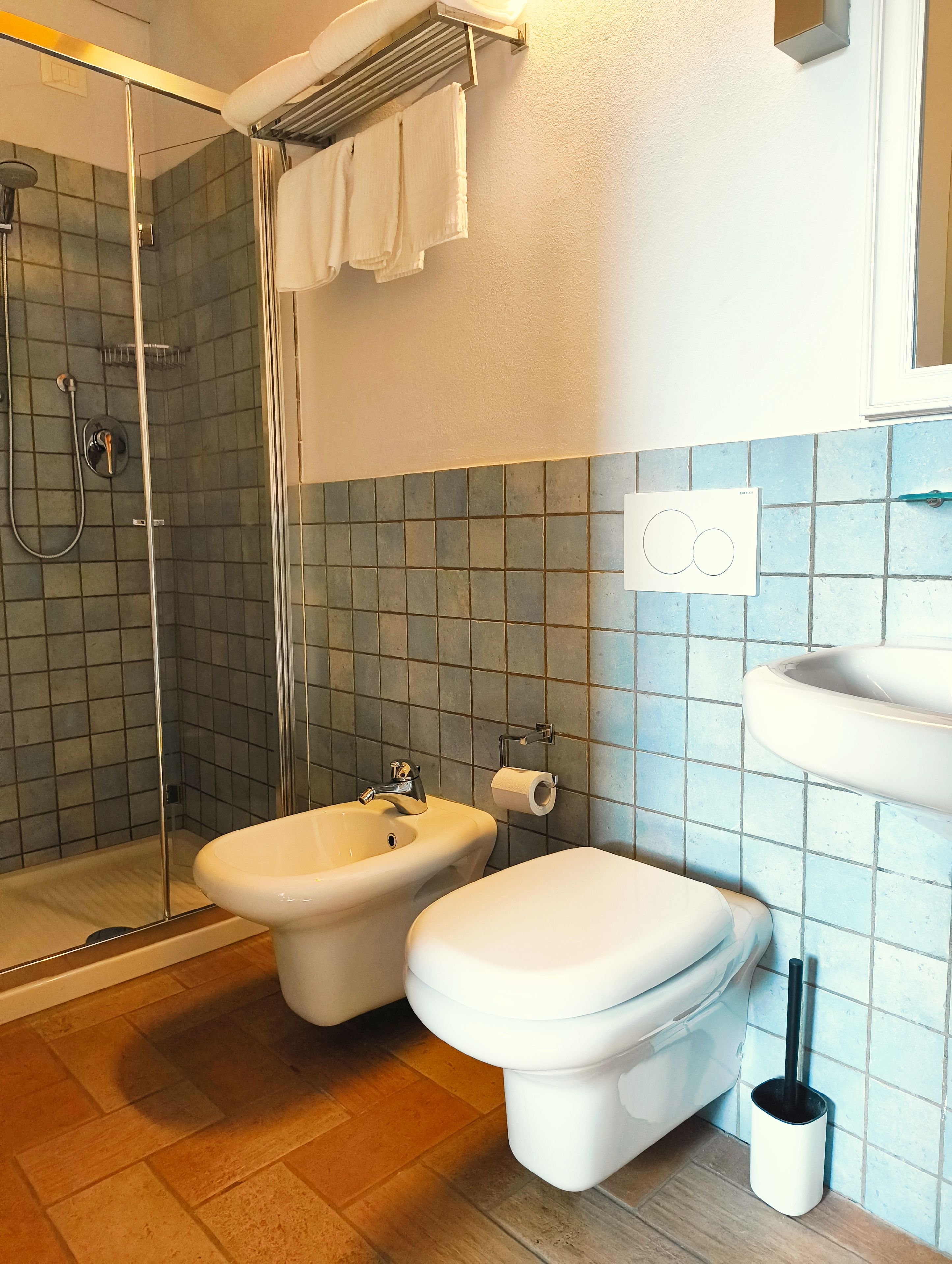 Une salle de bain équipée d’une douche, d’un bidet, de toilettes et d’un lavabo.