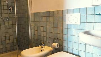 Une salle de bain équipée d’une douche, d’un bidet, de toilettes et d’un lavabo.