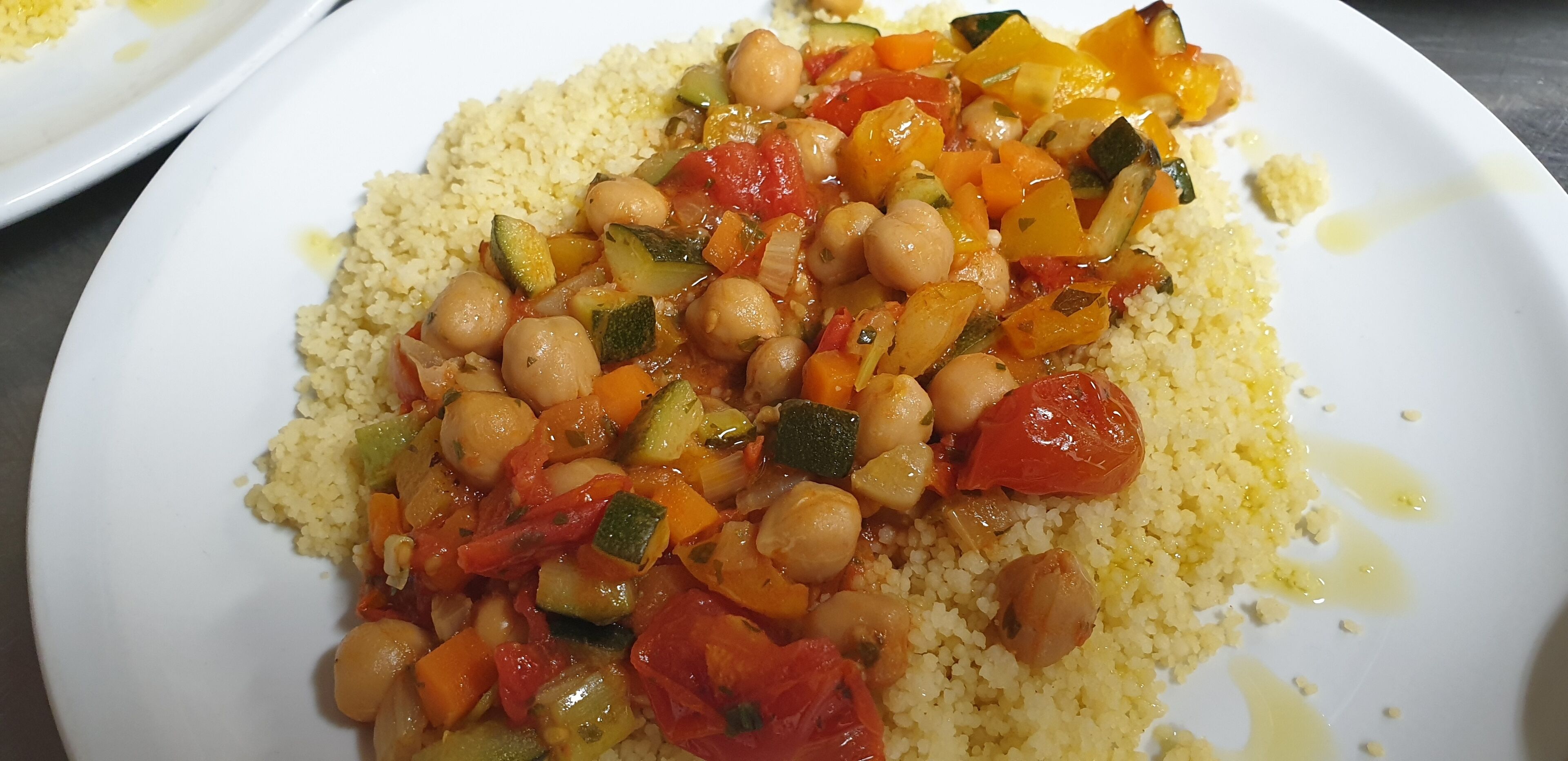 A plate of couscous with chickpeas and mixed vegetables.