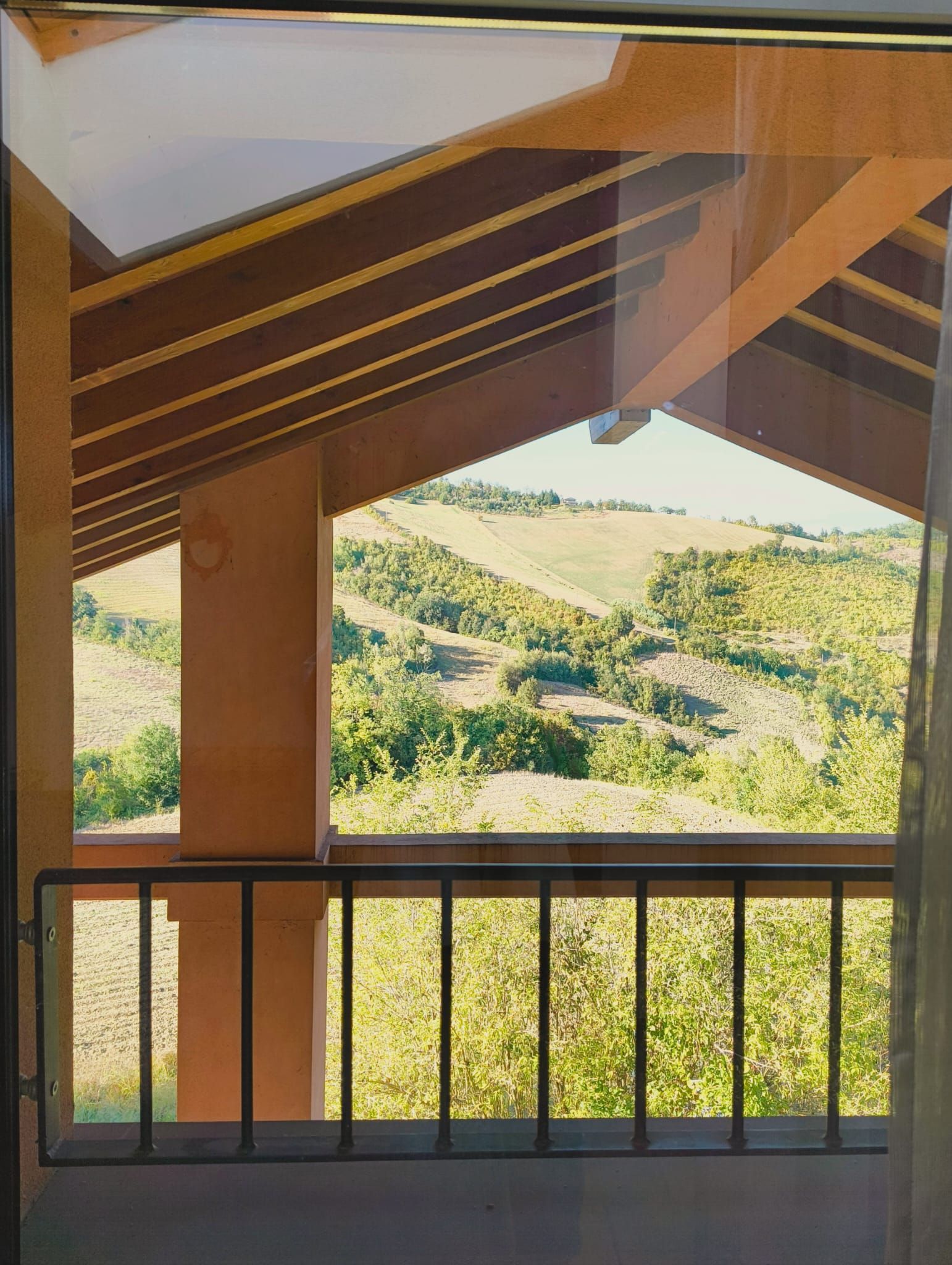 Ein Balkon mit Blick auf eine hügelige Landschaft.
