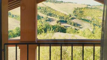 Ein Balkon mit Blick auf eine hügelige Landschaft.
