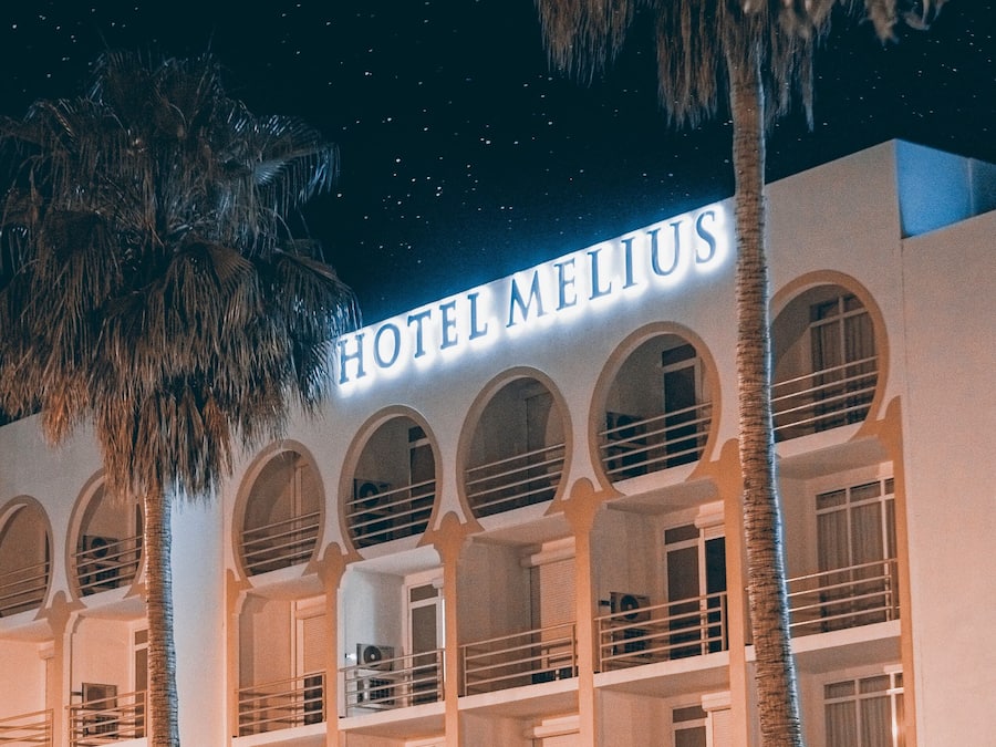 Un hotel con un cartel que dice "HOTEL MELIUS" y varios balcones con barandillas.