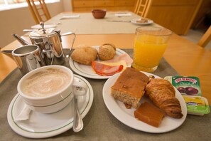 A breakfast table with coffee, croissants, and a glass of orange juice. - Hotel Melius (Beja)