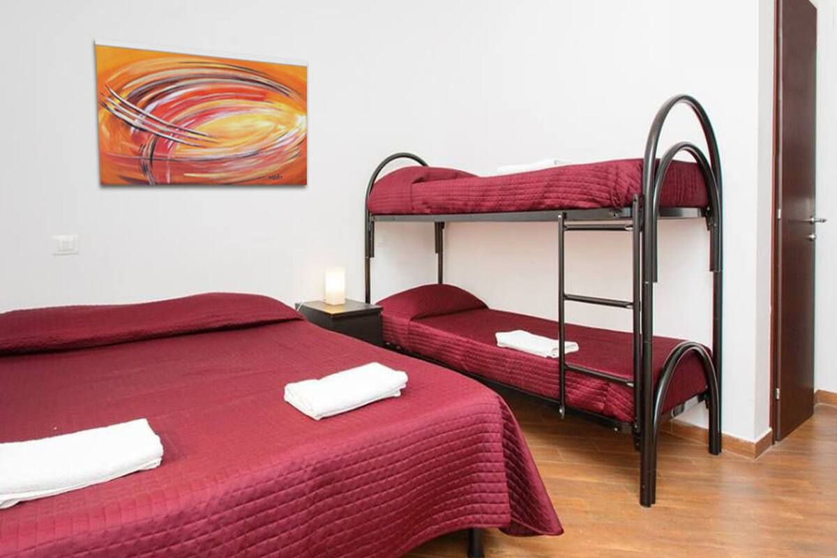 A room with bunk beds, a painting on the wall, and a door.