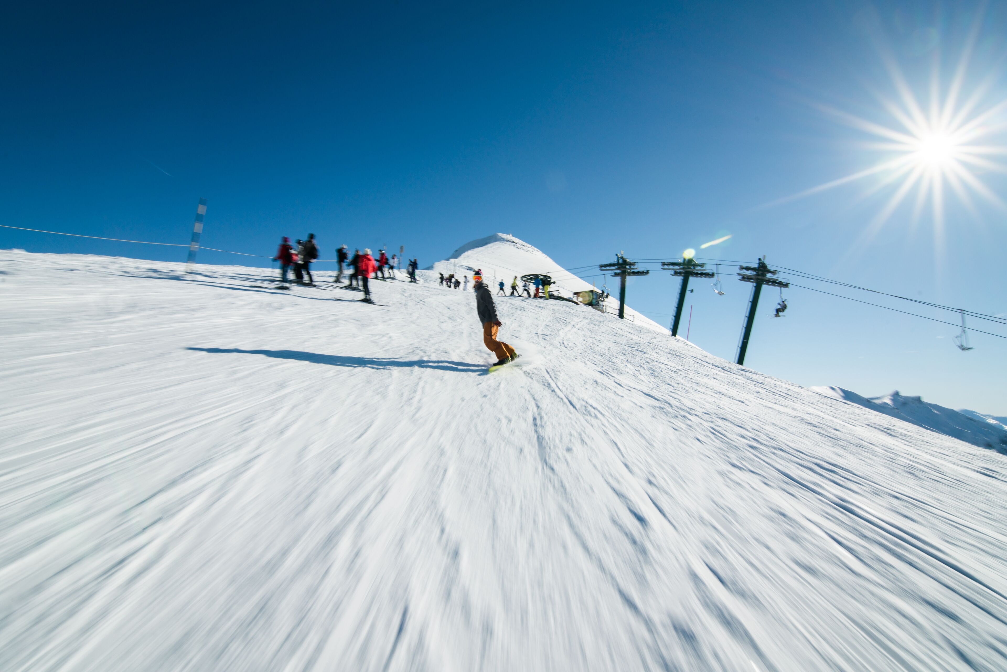 A snowy ski slope with skiers and a ski lift.