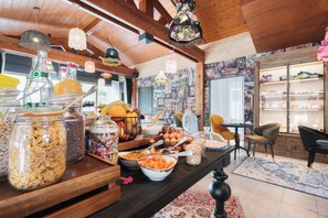 Una mesa de buffet con diversos alimentos y un interior de madera.