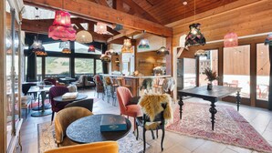 Un interior acogedor con vigas de madera, una zona de bar y diferentes disposiciones de asientos.