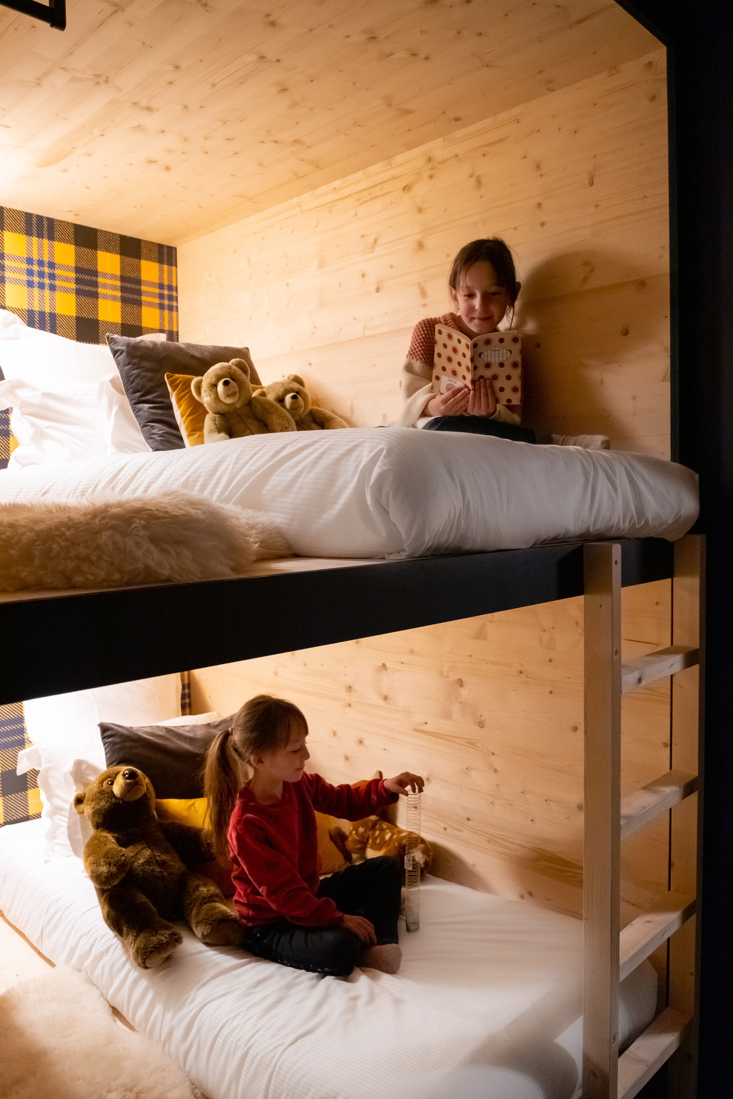Habitación con literas dobles, un niño arriba y otro abajo.