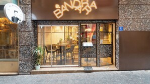 Un restaurante con un letrero de neón que dice "EL BANDARA" y puerta de vidrio.