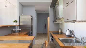 A modern kitchen with wooden countertops, stainless steel appliances, and a visible sink.