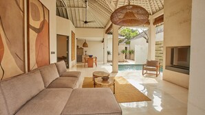 Amplia sala de estar con sofá, mesa de comedor y vista a la piscina.