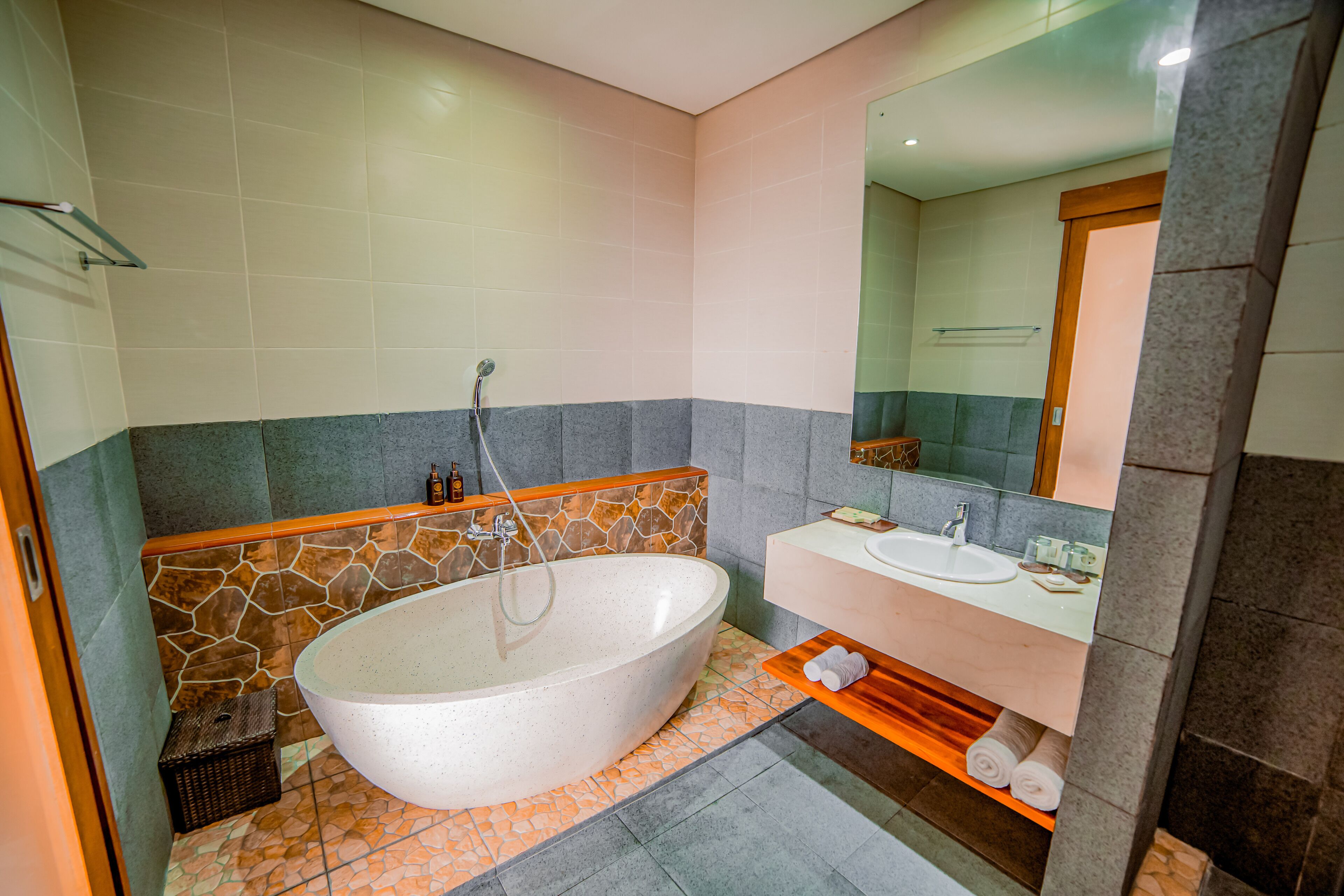 A modern bathroom with a freestanding bathtub, a vanity with a sink, and a large mirror.