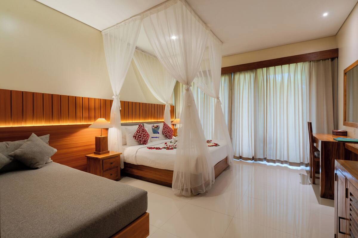 A bedroom with a bed, bedside table, and a nightstand.